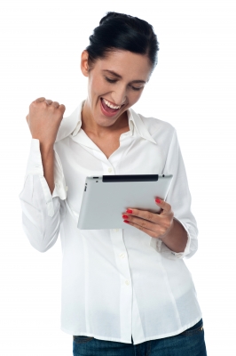 femme qui gagne contente devant sa tablette woman win tablet