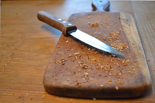 Un couteau posé sur une planche en bois.