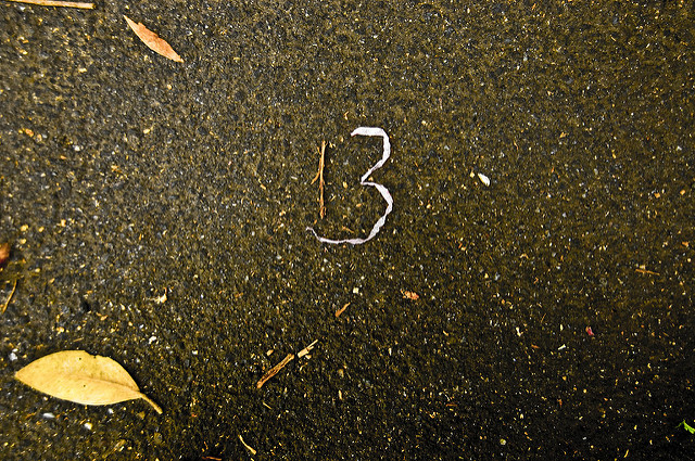 Le nombre 13 dessiné avec des brindilles sur le sol.
